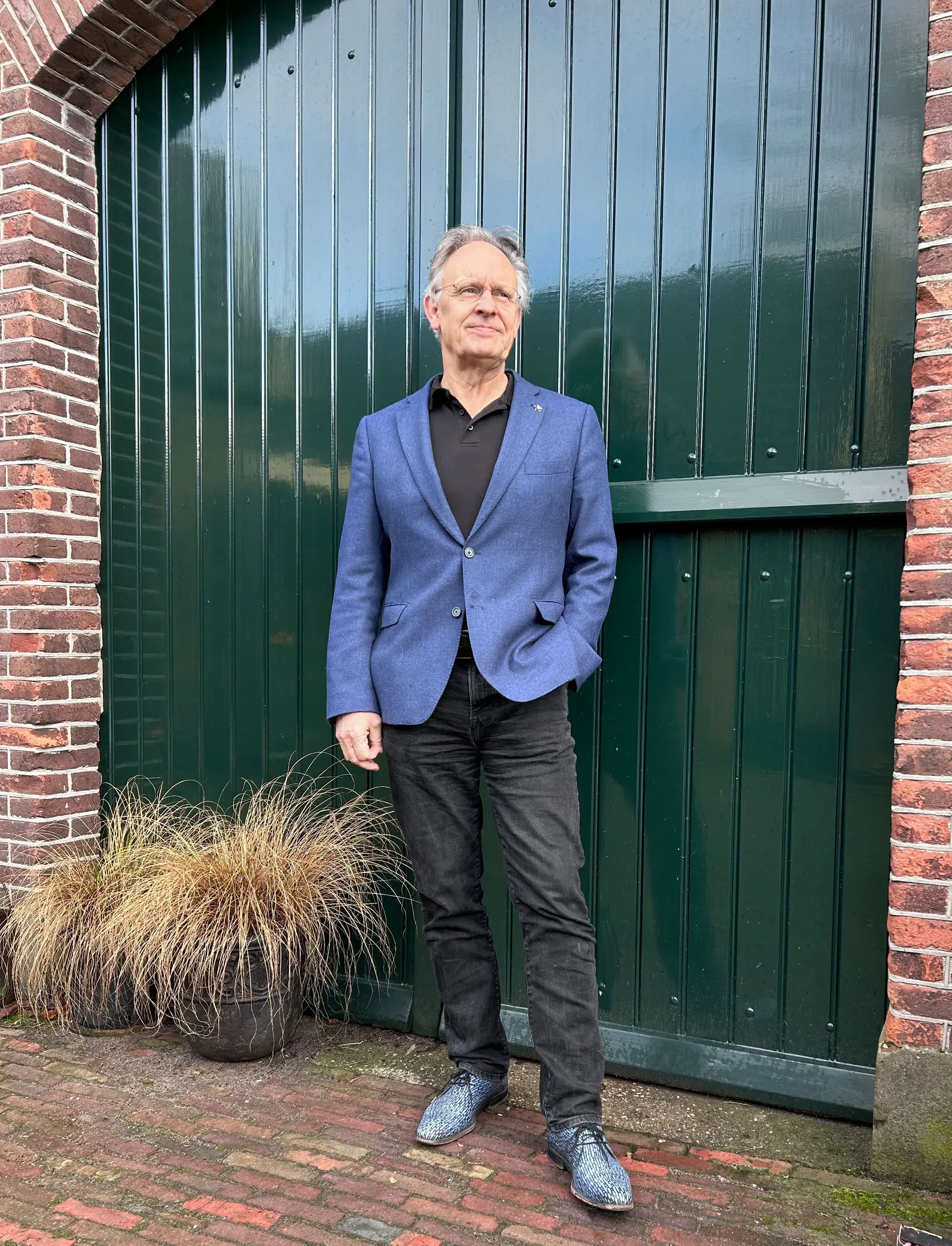 Portret van Martijn Stöfsel voor de groene deuren van de praktijk.